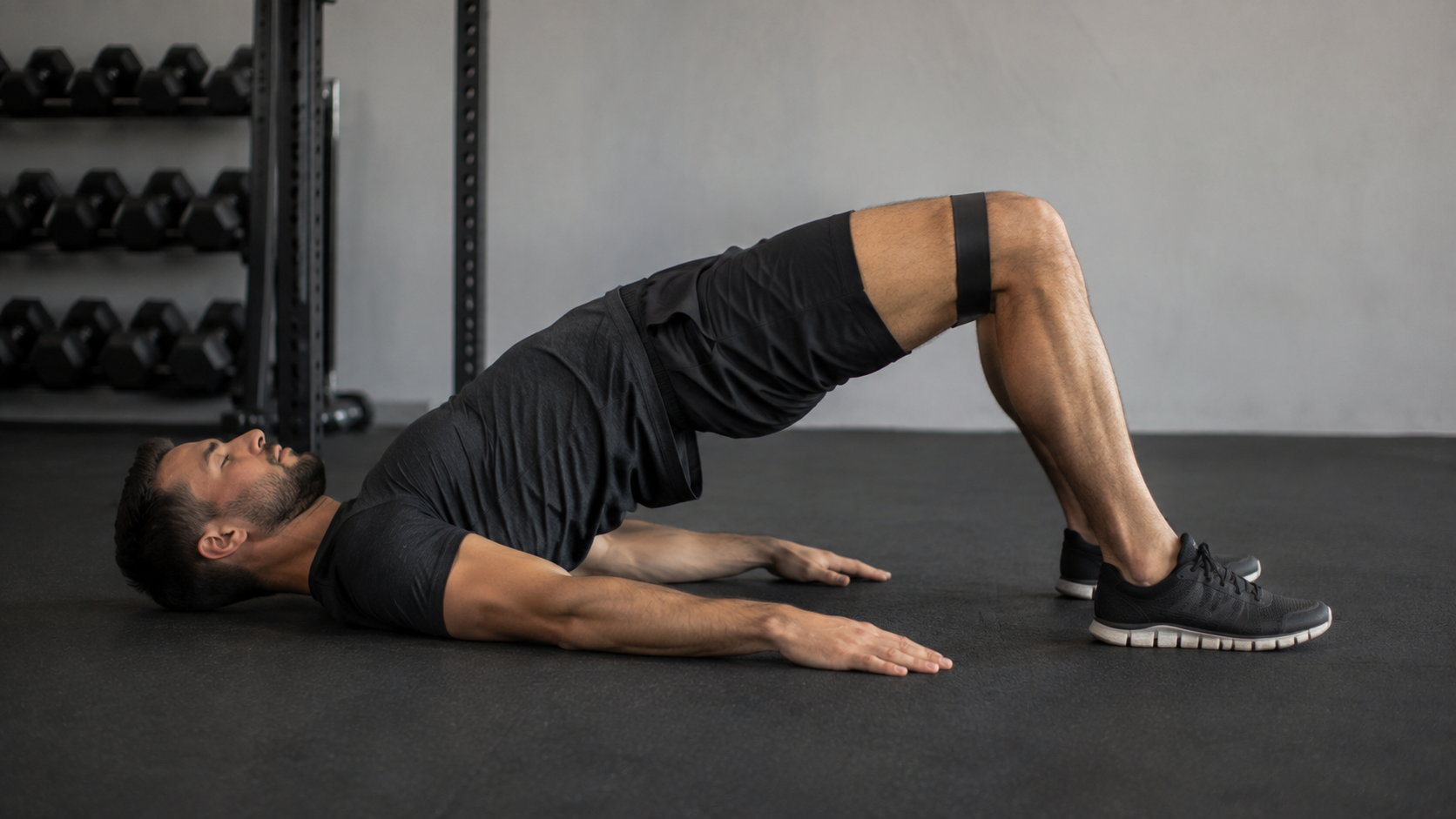 Person doing a band hip lift on the floor with the band above the knees
