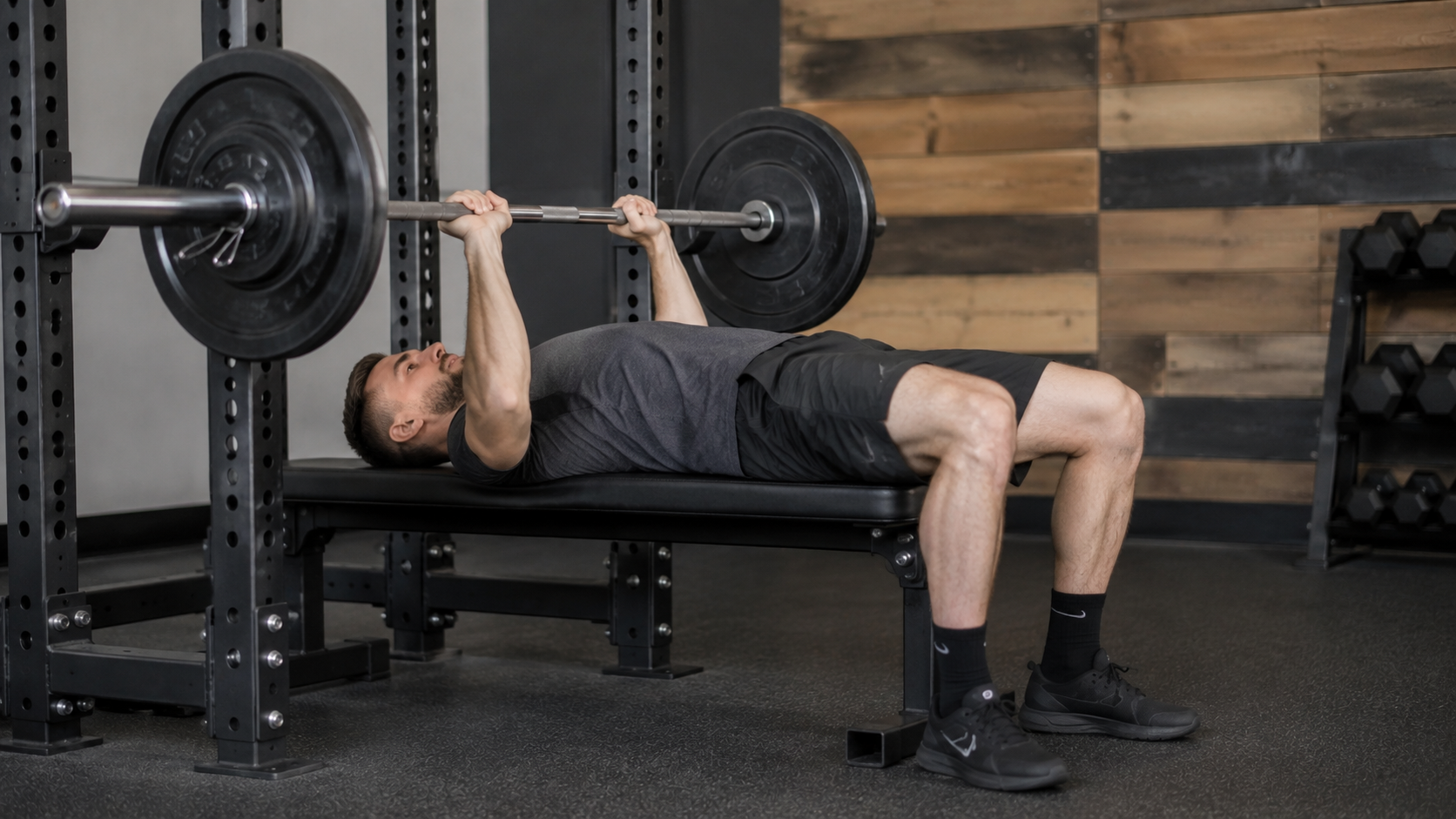 Lifter paused at the bottom of a close-grip bench press on a flat bench
