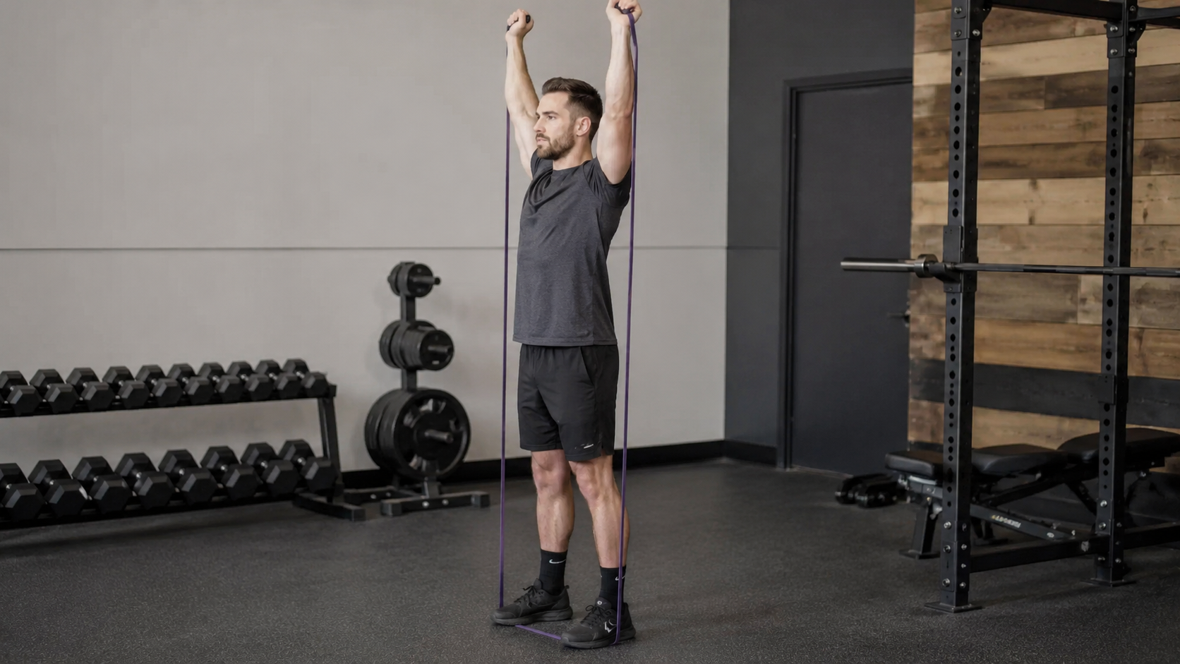 Person pressing a resistance band overhead while standing on it